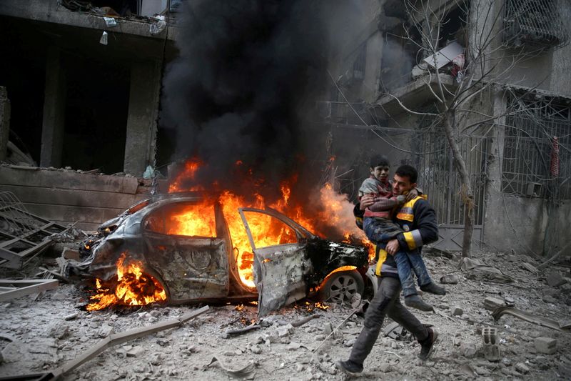 FILE PHOTO: A Syrian Civil Defence member carries a wounded