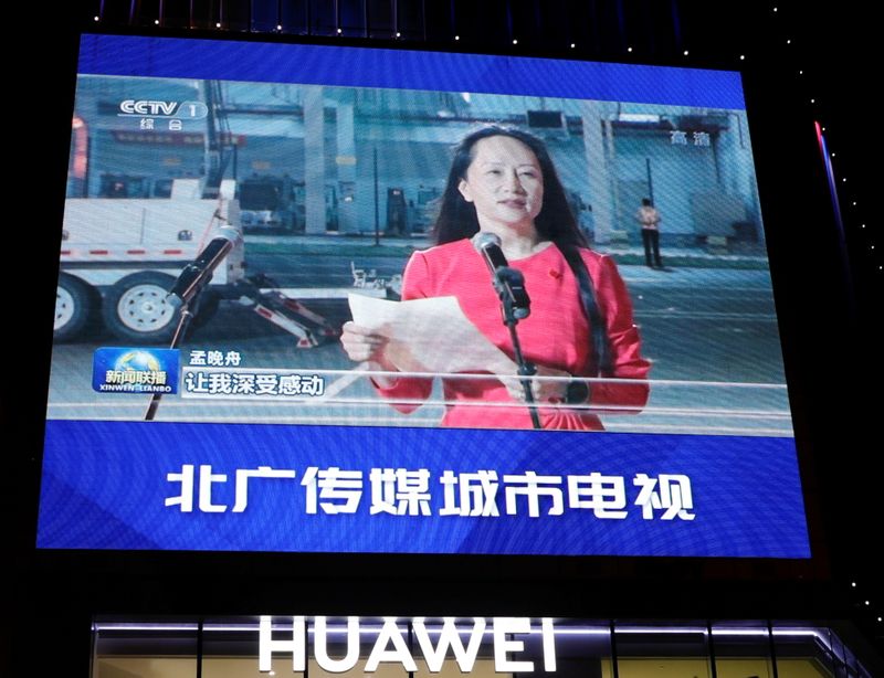 A giant screen on top of a Huawei store shows