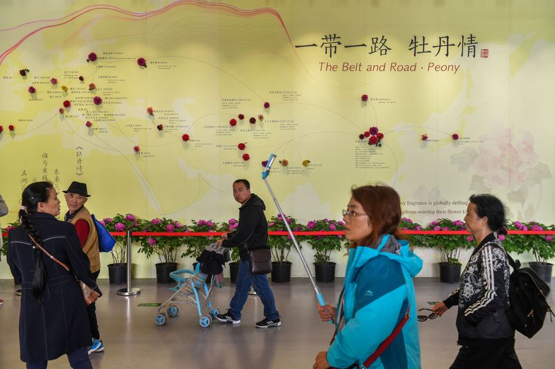 Visitors walk past a wall with a map showing the
