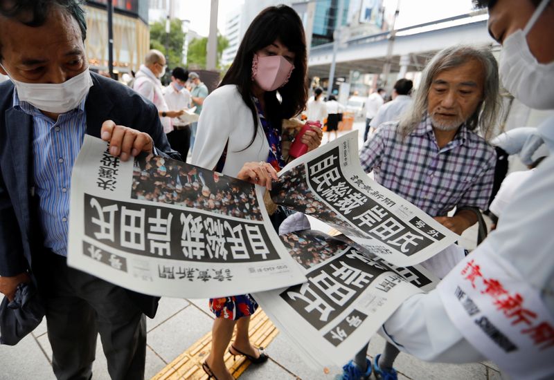 People receive extra editions of a newspaper reporting former Japanese