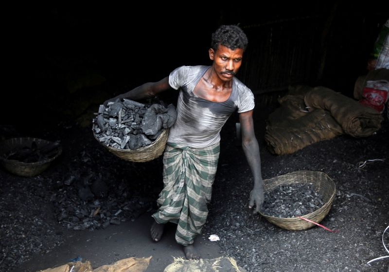 FILE PHOTO: A worker carries coal in a basket in