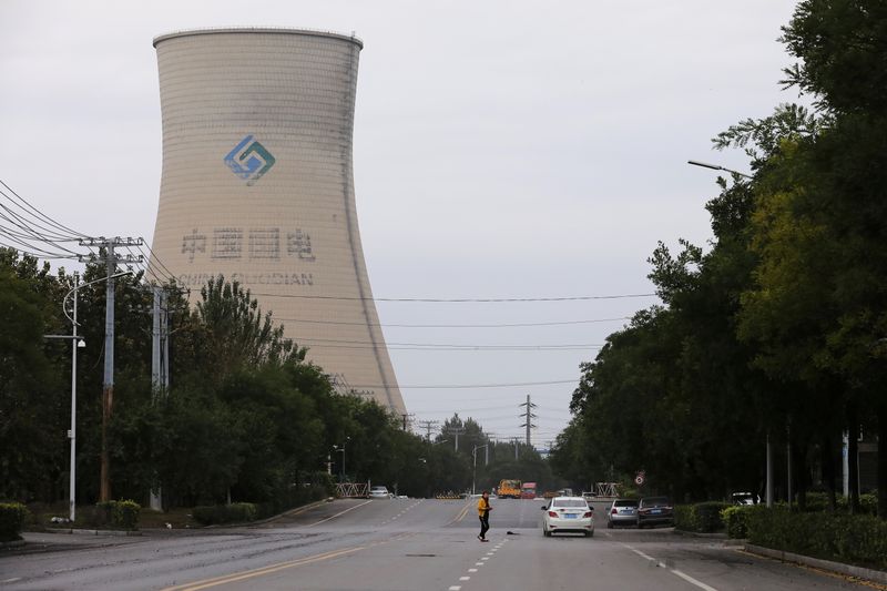 FILE PHOTO: Person walks near a China Energy coal-fired power