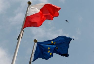 The flags of Poland and European Union flutter in front