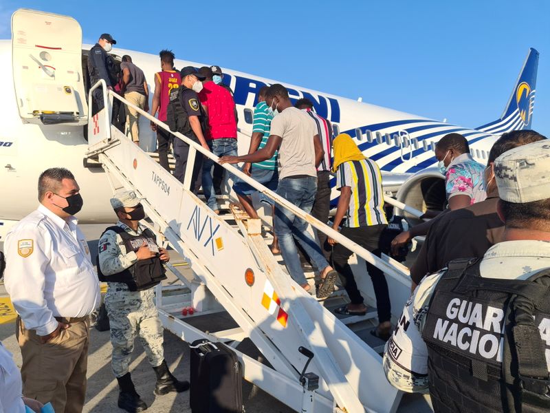 FILE PHOTO: Haitian migrants board a plane for a voluntary