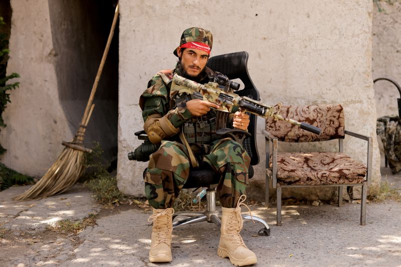 FILE PHOTO: A Taliban soldier sits outside a news conference
