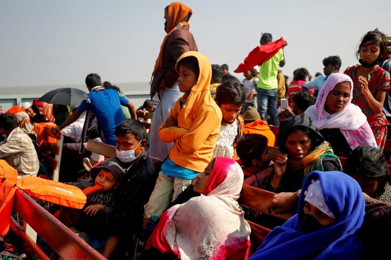 FILE PHOTO: Rohingya refugees sit on wooden benches of a