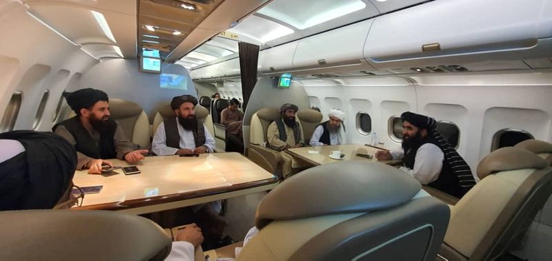 Taliban delegates are seated in a plane in an unidentified
