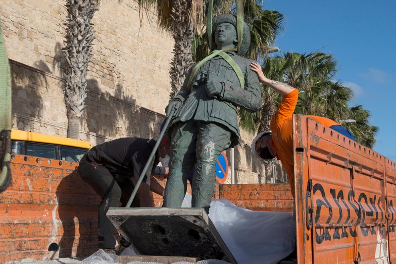 Local workers remove a statue of former Spanish dictator Francisco