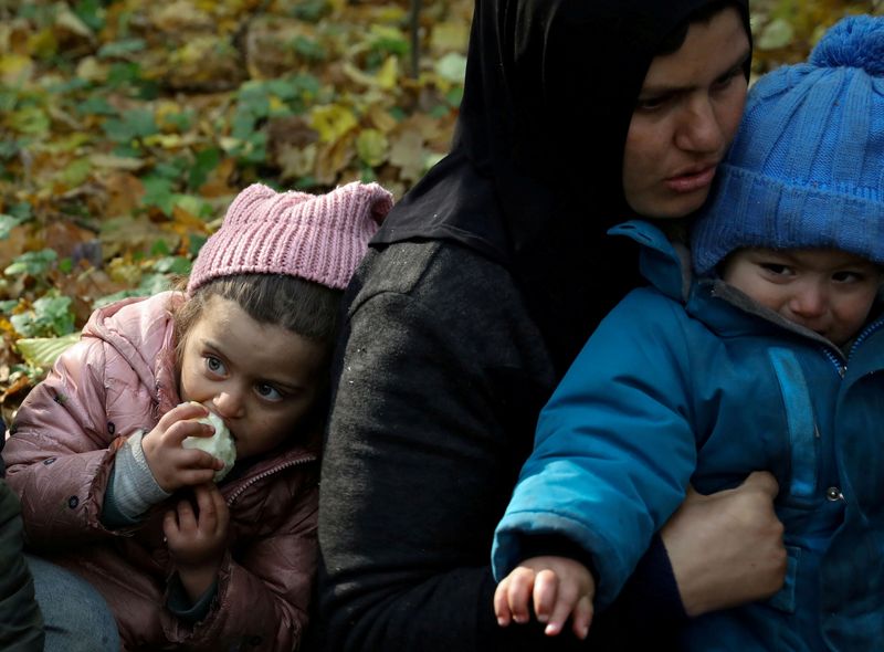 FILE PHOTO: An Iraqi migrant woman with children sits on