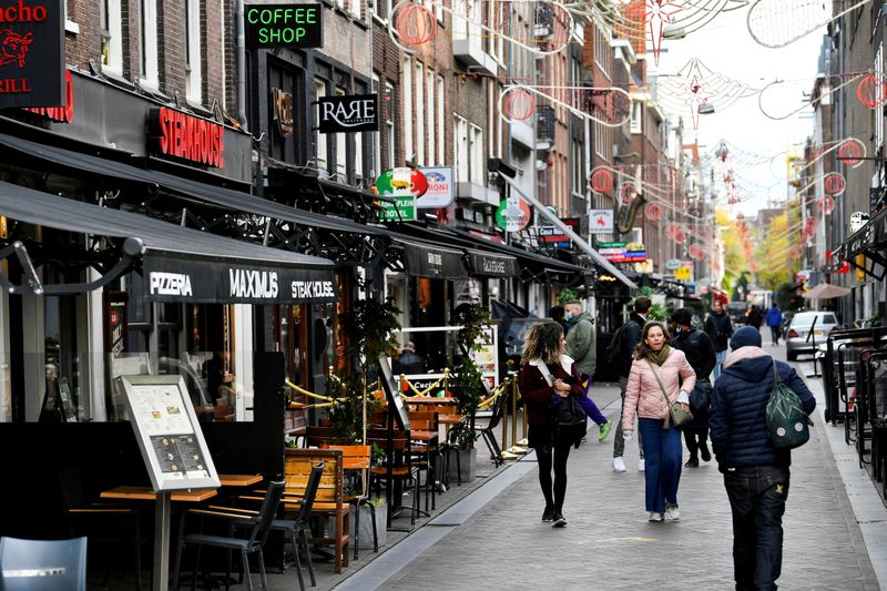 FILE PHOTO: People walk past restaurants and bars in Amsterdam