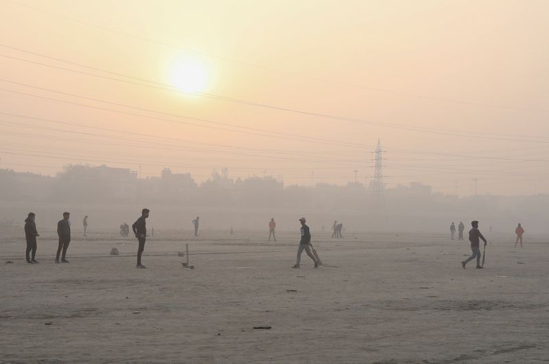 People play cricket on the floodplains of the Yamuna river
