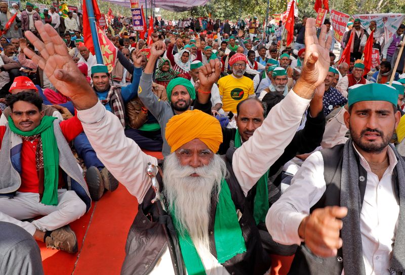Farmers shout slogans during a mass rally to demand minimum