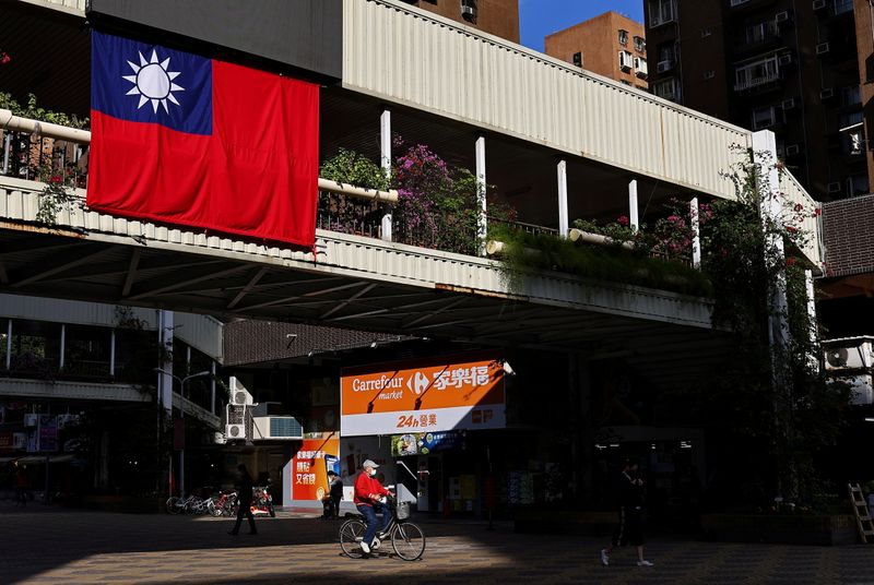FILE PHOTO: A man cycles past a Taiwan flag in