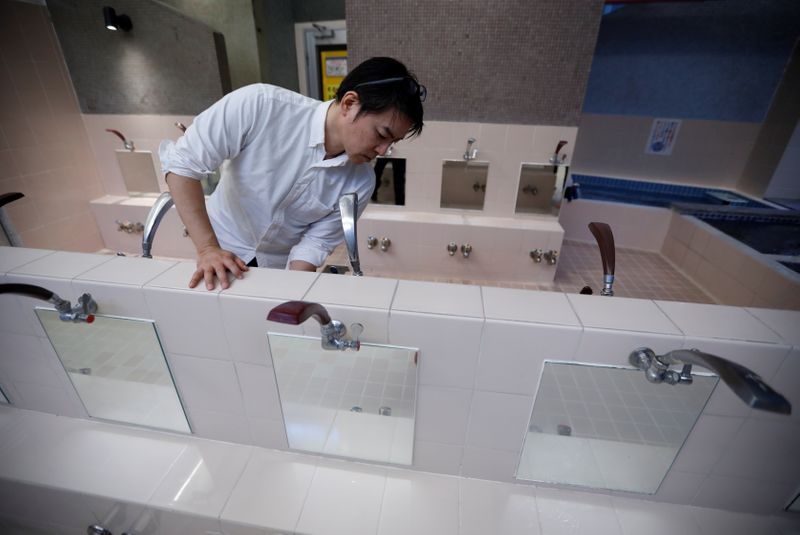 Tokuji Ito, the proprietor of a Japanese public bathhouse, prepares