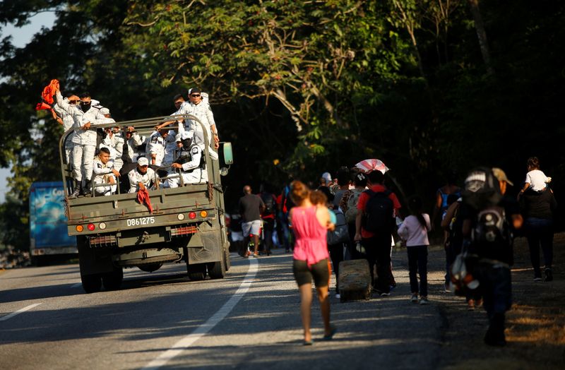 Migrants take part in a caravan heading to the U.S.