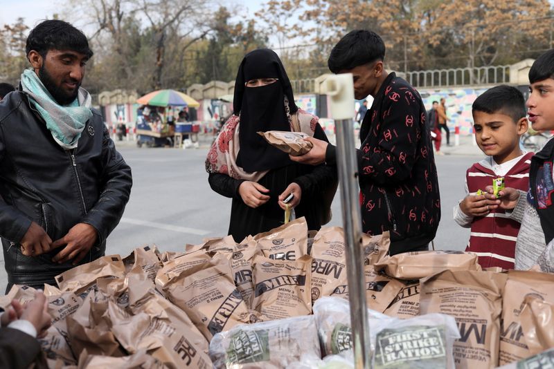 FILE PHOTO: Afghan woman buys food left behind by the
