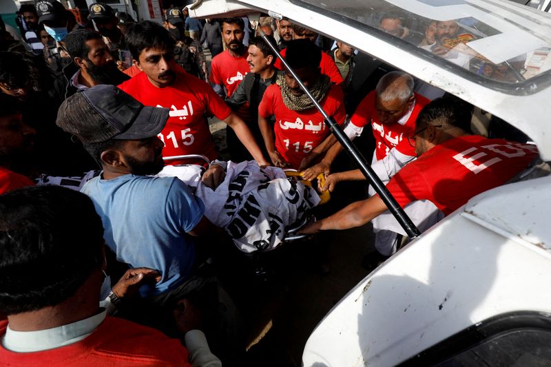 Rescue workers move a body into an ambulance after a