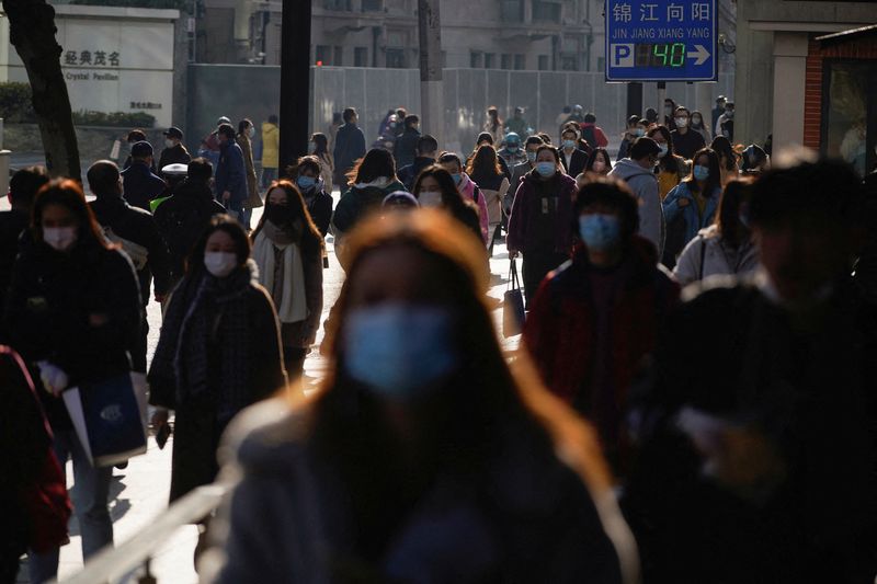 FILE PHOTO: People wearing protective masks walk on a street,
