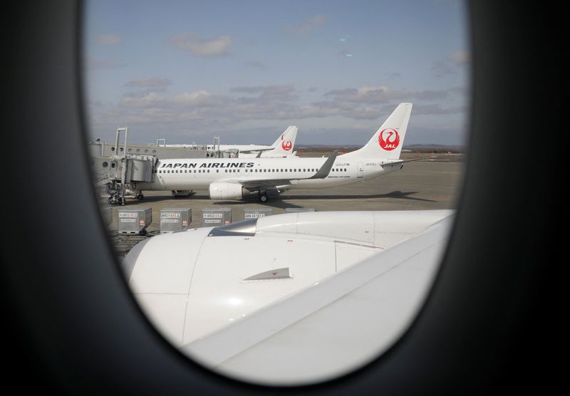 Japan Airlines (JAL) planes sit on the tarmac at New