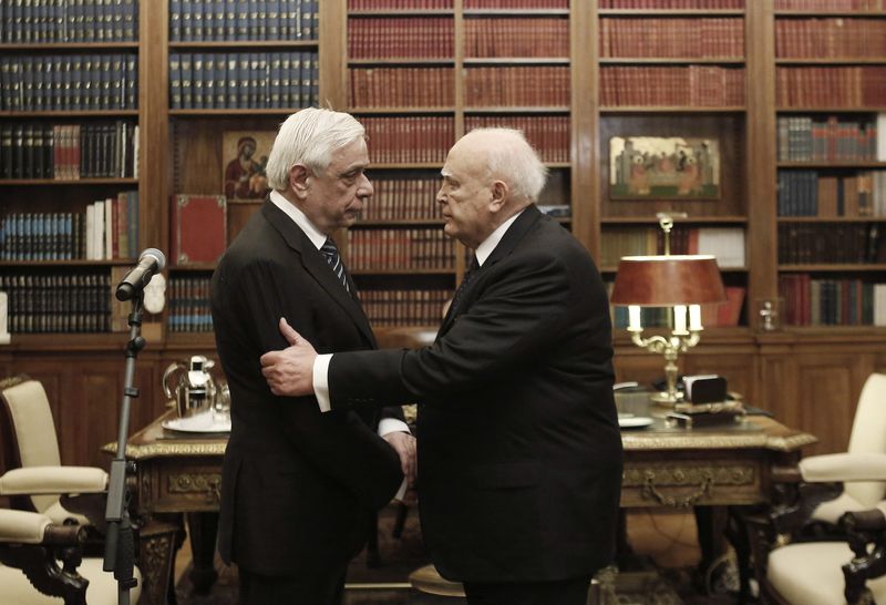 Outgoing Greek President Papoulias shakes hands with newly elected President