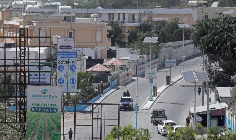A Somali police truck drive along the empty street in
