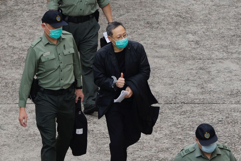 Pro-democracy activist Benny Tai flashes thumbs up as he walks