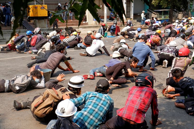 Protesters lie on the ground after police open fire to