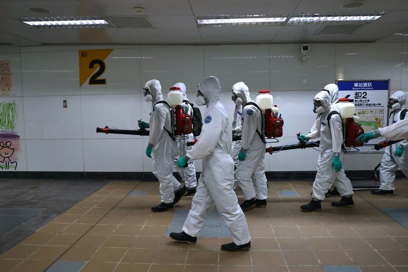 Soldiers in protective suits disinfect a metro station following a
