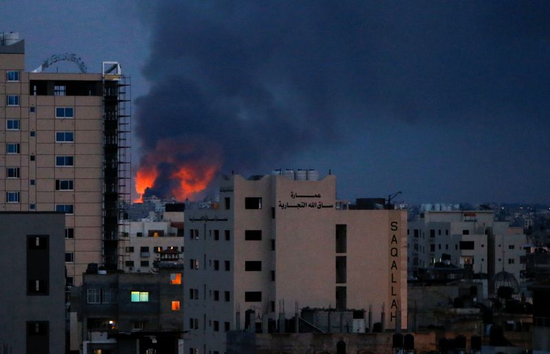 Smoke and flames are seen above buildings in Gaza