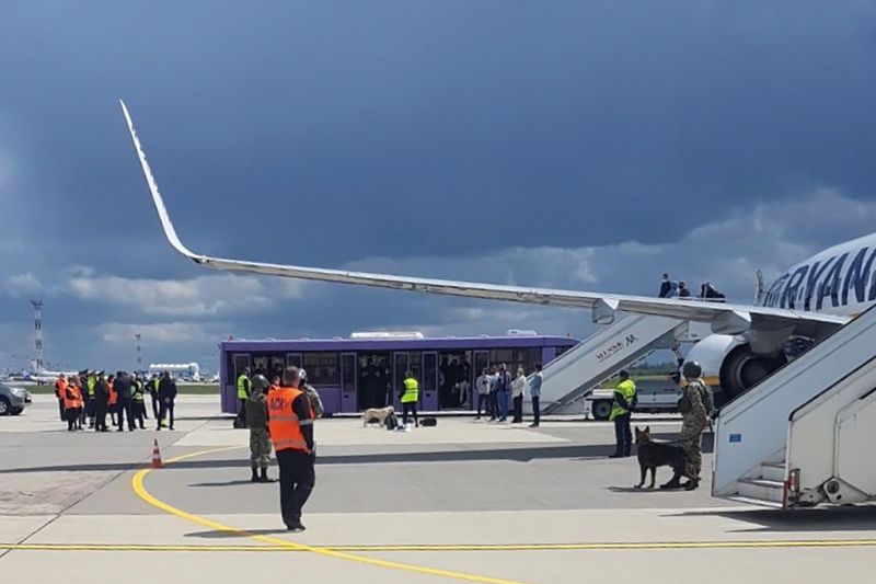 Airport personnel and security forces are seen on the tarmac