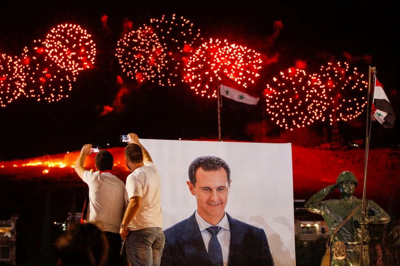 Supporters of of Syria’s President Bashar al-Assad celebrate after the