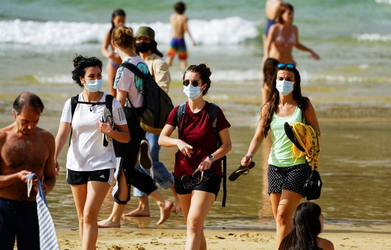 People wear masks at La Concha beach after Spain introduced
