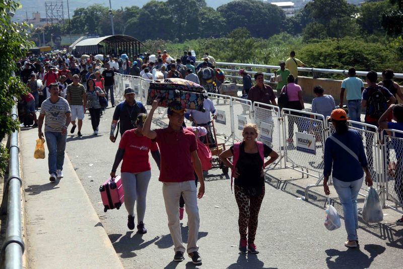 FILE PHOTO: People walk across Simon Bolivar bridge at the