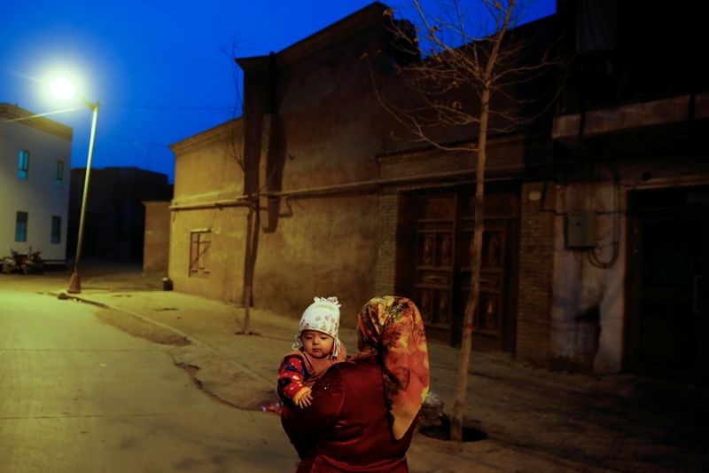 FILE PHOTO: A woman carries a child at night in