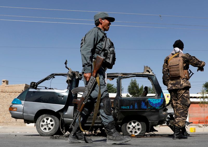 FILE PHOTO: Afghan police officer inspects a damaged van after
