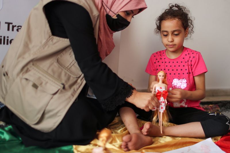 A psychologist plays with Palestinian girl Suzy Eshkuntana in Gaza