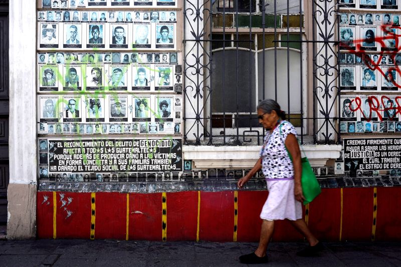 FILE PHOTO: A woman walks in front of a wall