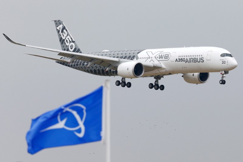 FILE PHOTO: An Airbus A350 jetliner flies over Boeing flags