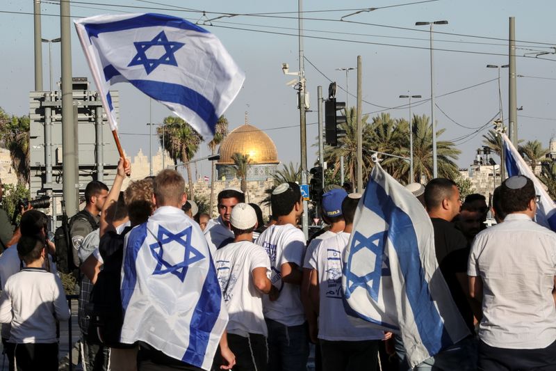 Israelis walk with flags outside Jerusalem’s Old City