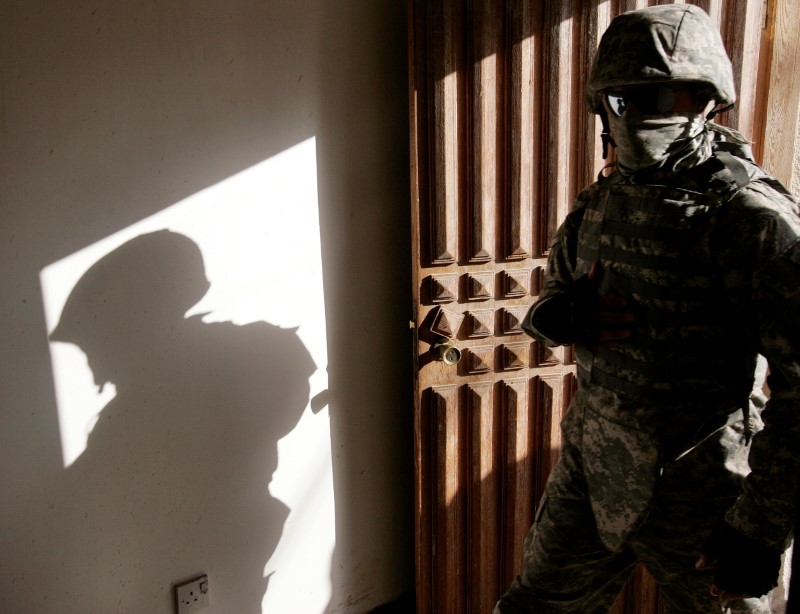 FILE PHOTO: An Iraqi interpreter enters a house during a