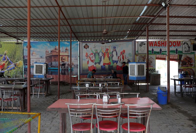 Waiters wait for customers at a dhaba, a small restaurant