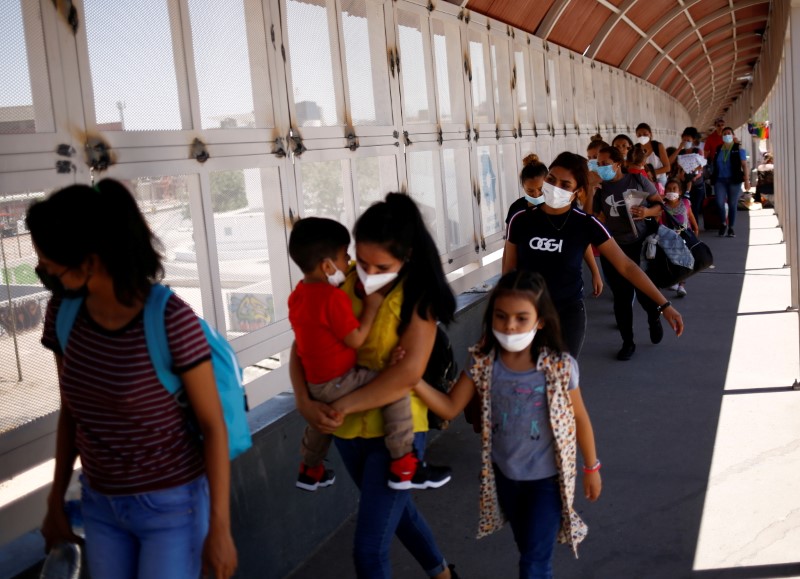 FILE PHOTO: Migrants from Central America walk across the Paso