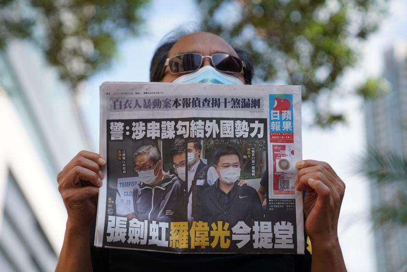 A supporter holds a copy of Apple Daily newspaper during
