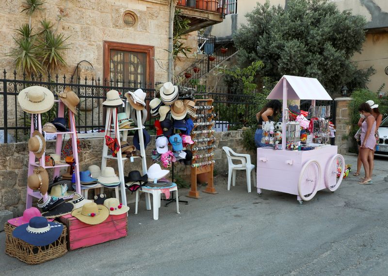 A street vendor sells accessories and hats along a street