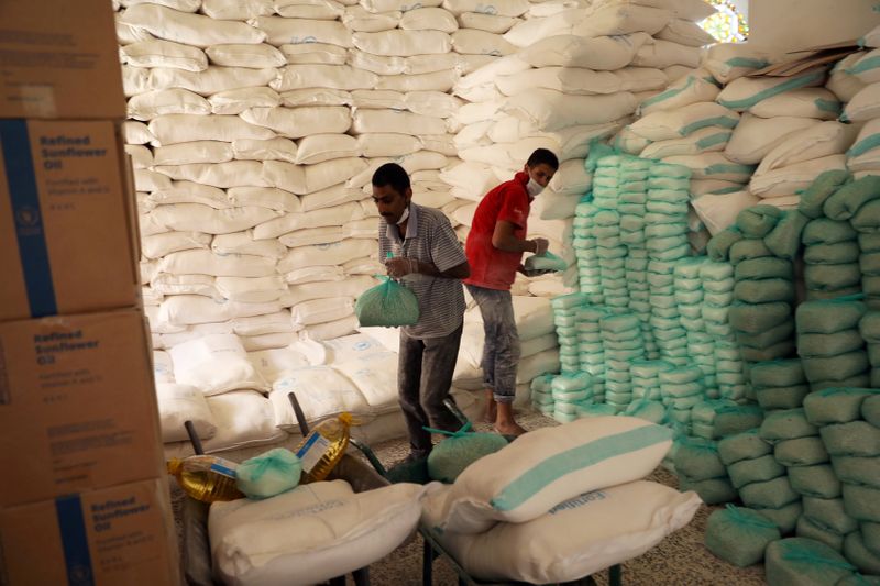 FILE PHOTO: Workers prepare foodstuff for beneficiaries at a food