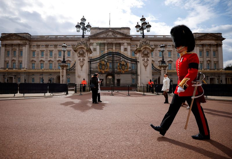 FILE PHOTO: A guardsman walks outside Buckingham Palace in London