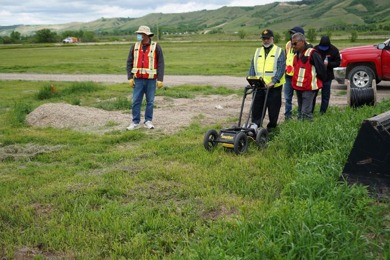 A crew performs a ground-penetrating radar search of a field