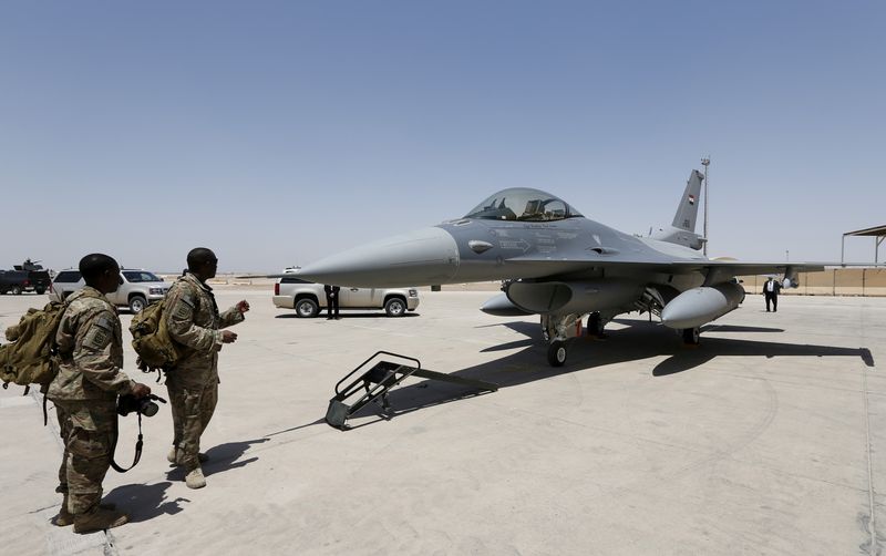 FILE PHOTO: U.S. Army soldiers look at an F-16 fighter