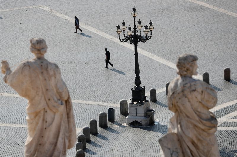 People walk in St. Peter’s Square at the Vatican