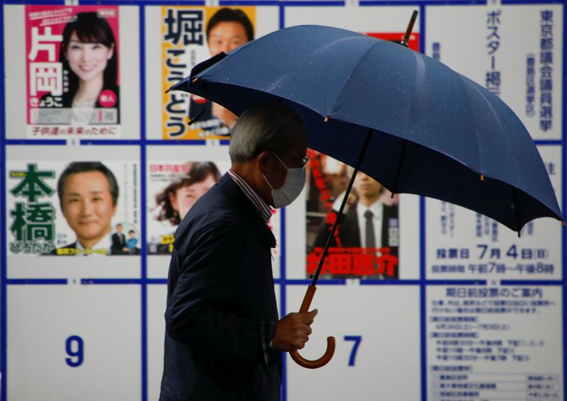 A voter walks past a board displaying posters of candidates